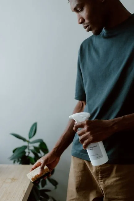 about-01 A couple wrapping furniture in a bright apartment, preparing to move.